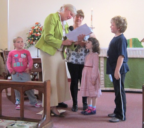 The children's group, Jigsaw, and leader Marie Maull present Jackie with leaving gifts.