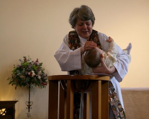 The Rev'd Stefanie Hodges baptises Alexander.