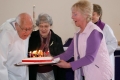 Harold Barber blows out the candles on his birthday cake. Next to Harold is wife Rae, Penny Ellis os presenting the cake, while the Rev'd Stefanie Hodges, looks on.